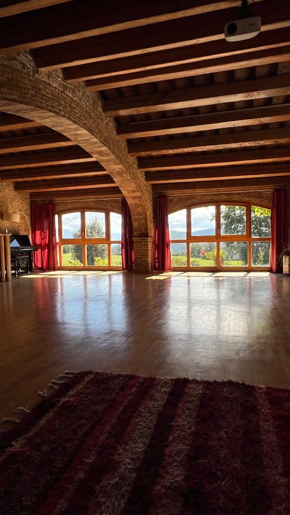 Sala de prácticas de la masía — vigas de madera y vistas a la montaña